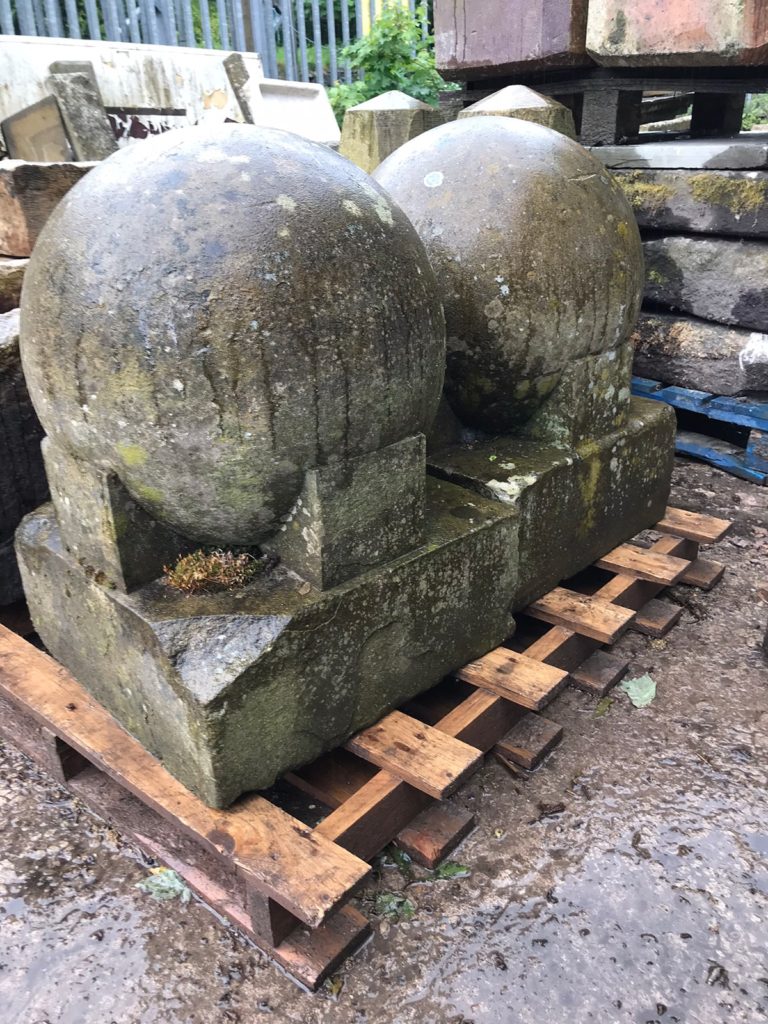 Stunning pair of late 19th Century sandstone pier caps depicting a ball held in a claw on a square base